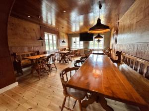 uma grande mesa de madeira numa sala com mesas e cadeiras em Orø Kro & Hotel em Orø