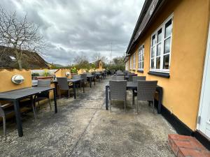 eine Reihe von Tischen und Stühlen außerhalb eines Gebäudes in der Unterkunft Orø Kro & Hotel in Orø