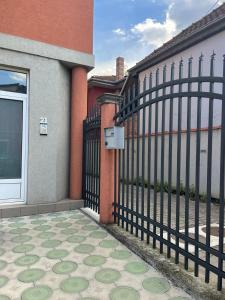 a fence in front of a building with a sidewalk at Apartman Jovana 2 in Jagodina