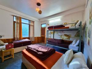 a room with two bunk beds and a couch at The Bunker Burwa Manali in Manāli