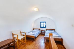 ペリヴォロスにあるThalassitis Coastal Apartmentsのベッド2台とテーブルと椅子のある部屋