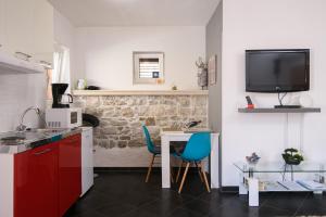 a kitchen with a table and two chairs and a tv at Apartments Trabakul in Trogir