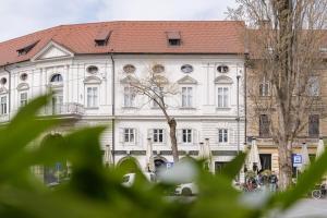 a large white building with a red roof at Apartment Napoleon in Ljubljana