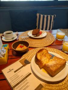 stół z dwoma talerzami jedzenia i tostów w obiekcie Kastel Jampa Hotel w mieście João Pessoa