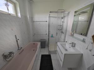 Baño blanco con bañera y lavamanos en Patyo Orosháza en Orosháza