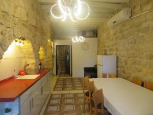 a kitchen with a counter and a sink and a refrigerator at אורות בעתיקה - צימרים ונופש בצפת in Safed