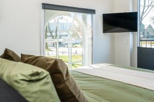 1 dormitorio con 1 cama, TV y ventana en B&B Zijlsterkerk, 