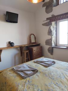 a bedroom with a bed with towels on it at Family stay by the beach in Chwilog