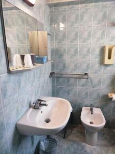y baño con lavabo y aseo. en Hotel Olympic, en Milano Marittima