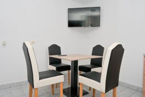 a table and chairs with a television on a wall at Apart Cobras Jajce in Jajce
