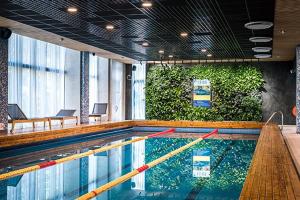 a swimming pool in a building with a pool at Seaside apartment Albatross, 16 in Ķesterciems