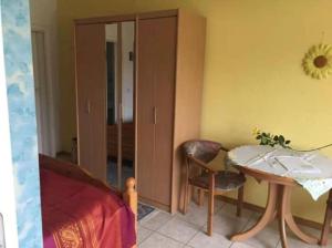 een slaapkamer met een tafel, een stoel en een bed bij FeWo-Mitten In Schwarzwald in Titisee-Neustadt +8 foto's
