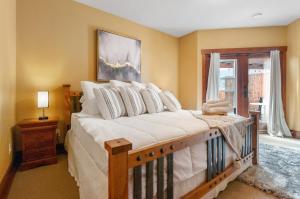 una camera da letto con un letto con lenzuola bianche e una finestra di Casa Grande Inn & Suites a Penticton