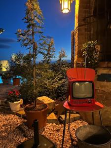 an old red tv sitting on a chair in a yard at Appartamento Cico in Andezeno