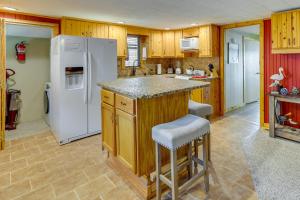 uma cozinha com armários de madeira e um frigorífico branco em Pet-Friendly Grove Vacation Rental with Boat Dock! em Grove