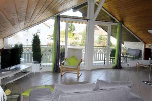 una veranda schermata con divano e TV di Ferienwohnung Kirschenlohr a Ober-Abtsteinach
