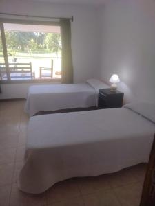 2 Betten in einem Zimmer mit Fenster in der Unterkunft Las Marukas in San Antonio de Areco
