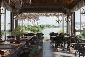 ein Restaurant mit Tischen und Stühlen und Flussblick in der Unterkunft Hanoi Morning Hotel in Hanoi