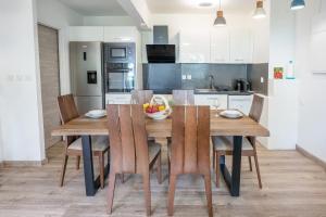 a kitchen with a wooden dining table and chairs at Le Sable d'Or in La Saline les Bains