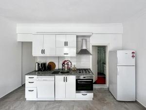 a white kitchen with a stove and a refrigerator at Kaş Centre - The Rush Apart-2 in Kaş