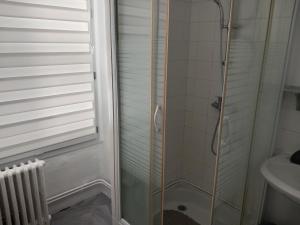 une douche avec une porte en verre à côté d'un lavabo dans l'établissement MELANIE, à Ahun