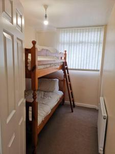 a room with two bunk beds in a room with a window at Shielded Serenity - 3 BR House in South Shields