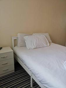 a bed with two pillows and a night stand at Shielded Serenity - 3 BR House in South Shields