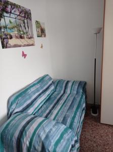 uma cama num quarto com lençóis listrados em Da Enzo centro Imperia a 5 minuti a piedi dal mare em Imperia