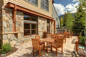 a patio with tables and chairs in front of a building at Jackpine & Black Bear Condominiums by Keystone Resort in Keystone