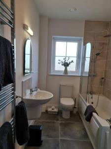 La salle de bains est pourvue d'un lavabo, de toilettes et d'une baignoire. dans l'établissement Abbeyfort Kinsale, à Kinsale