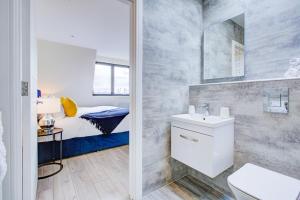 a small bathroom with a bed and a sink at Hybrid Resi - London, Sutton, FREE on-site Car or Van parking in Cheam +65 photos