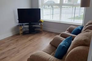sala de estar con sofá y TV de pantalla plana en Abbeyfort Kinsale, en Kinsale