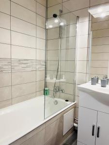 La salle de bains est pourvue d'une douche, d'une baignoire et d'un lavabo. dans l'établissement le Clos des Trolles - Hauteurs d'Annecy, à Annecy