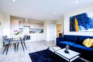 a living room with a blue couch and a table at Hybrid Resi - London, Sutton, FREE on-site Car or Van parking in Cheam
