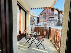 a patio with two chairs and a table on a balcony at le Clos des Trolles - Hauteurs d'Annecy in Annecy