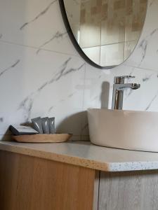 a bathroom counter with a sink and a mirror at LEGENDS EXECUTIVE LODGE in Choma