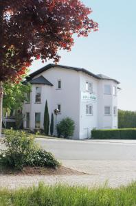 un bâtiment blanc sur le côté d'une route dans l'établissement Hotel Asslar, à Aßlar