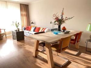 a living room with a wooden table and a couch at Amstel BeachHouse Egmond aan Zee, 50m from the beach! in Egmond aan Zee +21 photos