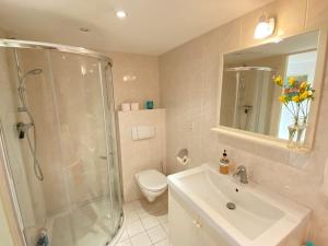 a bathroom with a shower and a sink and a toilet at Amstel BeachHouse Egmond aan Zee, 50m from the beach! in Egmond aan Zee