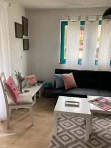 a living room with a black couch and two tables at Holiday Home Tunnel Ravne in Visoko