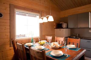 a dining room with a table and chairs and a kitchen at Villa Hapero in Mikkeli