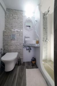 La salle de bains est pourvue d'un lavabo, de toilettes et d'un miroir. dans l'établissement Petit Sunset, à Ioulída