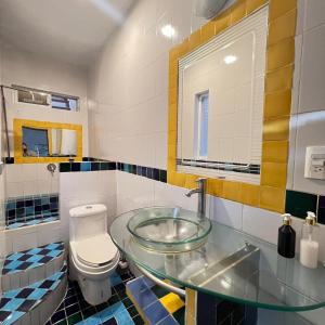 a bathroom with a glass sink and a toilet at Hostal Luna 49 in Querétaro +19 photos