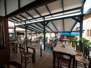 a restaurant with tables and chairs in a room at Hellas in Palekastron