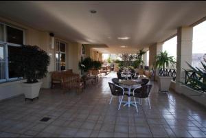 a patio with tables and chairs on a building at Araucária Flat Apto 305 in Ribeirão Preto