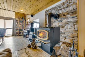 a fireplace in a living room with a stone wall at Cozy Mountain Home on 10 Acres with Fire Pit and Games in Thayne