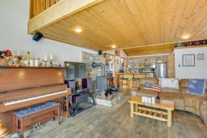 Cozy Mountain Home on 10 Acres with Fire Pit and Games في Thayne: غرفة معيشة بها بيانو وأريكة