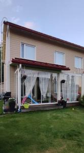 a house with a screened porch with white curtains at 100m2 moderni paritalo omalla pihalla Helsingissa in Helsinki