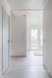 una habitación vacía con paredes blancas y una puerta abierta en 100m2 moderni paritalo omalla pihalla Helsingissa en Helsinki