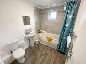 a bathroom with a toilet and a tub and a sink at 2 Bedroom Flat - Free Parking in Shenley Church End